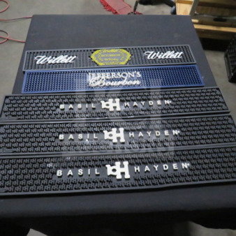 Assorted bar mats featuring Willett, Jefferson's Bourbon, and Basil Hayden branding in good condition.