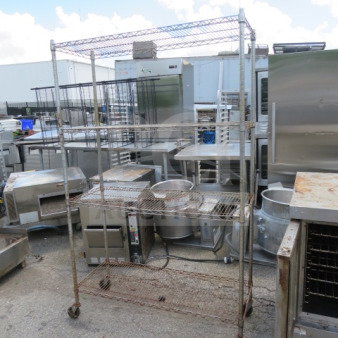 Metro shelf on casters with four wire shelves, size 48x18x77 inches, used condition, some rust visible.