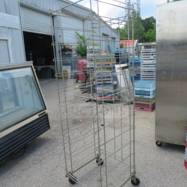 One metal bread rack on casters, 24x26x75 inches, used condition. Multiple tiers for storage, ideal for bakery display.