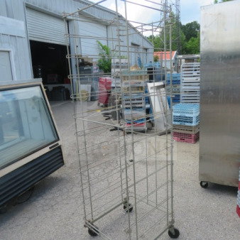 One metal bread rack on casters, 24x26x75 inches, used condition. Multiple tiers for storage, ideal for bakery display.