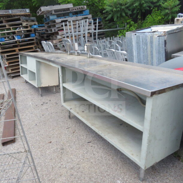 Long work table with under shelf, multiple outlets, and metal surface, measuring 174x23x35 inches. Used condition.