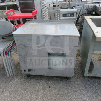 Industrial worktop table, metal, 34x24x35 inches, on wheels. Worn surface; suitable for kitchen or workshop use.