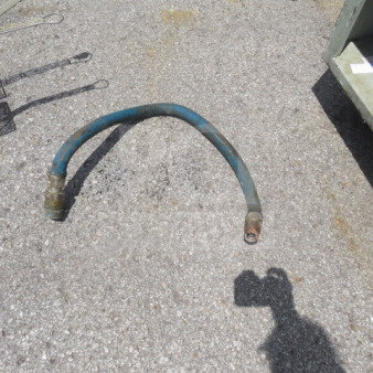 Vintage gas hose, blue, with connectors on both ends, in used condition on gravel surface. Suitable for specific machinery.