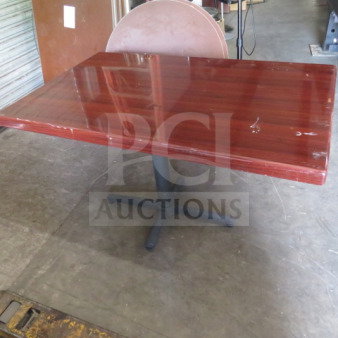 Wooden table with a glossy finish on a pedestal base. Dimensions: 48x30x30 inches. Shows minor surface wear.