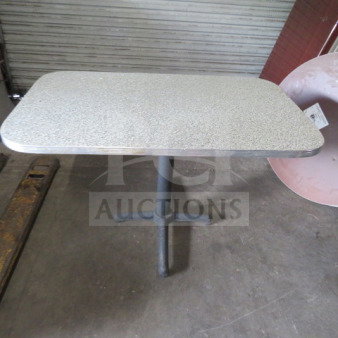 One laminate table with pedestal base, 48x30x30 inches, gray speckled top, black metal base, good condition.