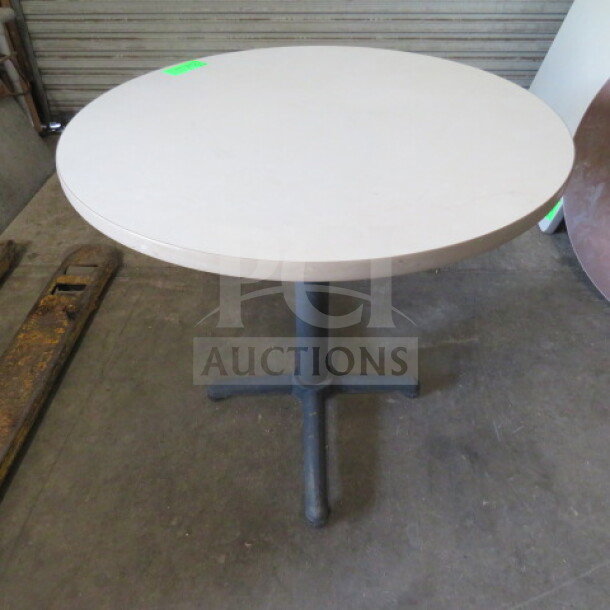 White round laminate table with pedestal base, 36x30 inches. Appears in good condition, suitable for various uses.