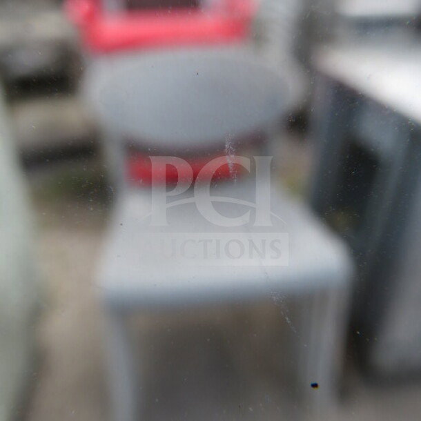 Assorted color indoor/outdoor chairs, stackable design, durable plastic, weather-resistant, mixed condition.