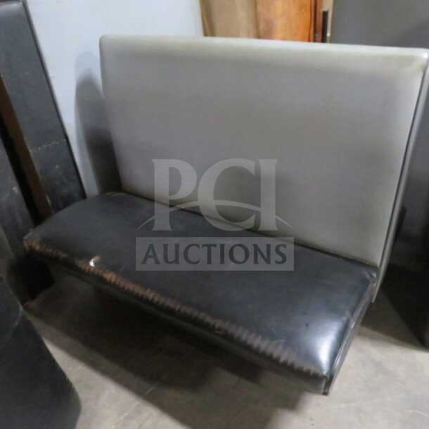 Black/gray single-sided cushioned booth with slight wear. High backrest, padded seat, sturdy construction. Ideal for restaurant use.