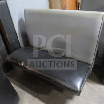 Black/gray single-sided cushioned booth, used condition, visible wear on the black seat, gray backrest, sturdy construction.