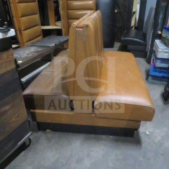 Brown double-sided cushioned booth, used condition, leather upholstery, sturdy frame, minor wear on edges.