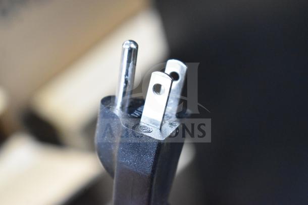 Close-up of a power plug for an Avantco ASM0013 meat slicer, showing a standard three-prong design.