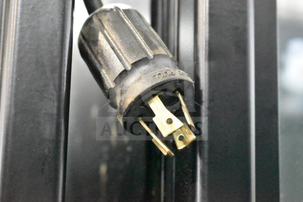 Close-up of True GDM-72F-HC freezer power plug, showing three prongs. Plug indicates 115/208-230V, 1-phase compatibility.