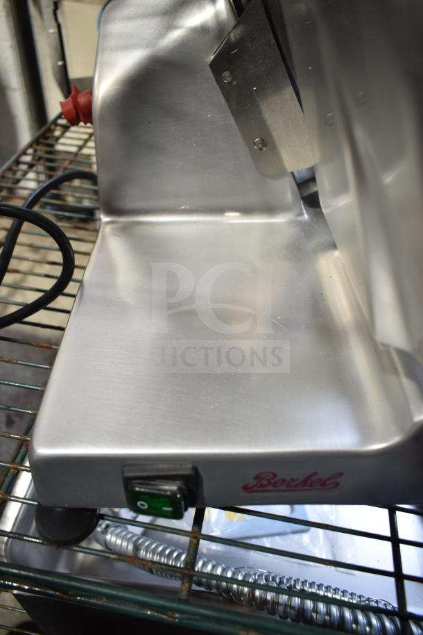 Berkel B10-SLC commercial meat slicer, new with minor scratches, features 10" blade, manual feed, 115V, blade sharpener included.