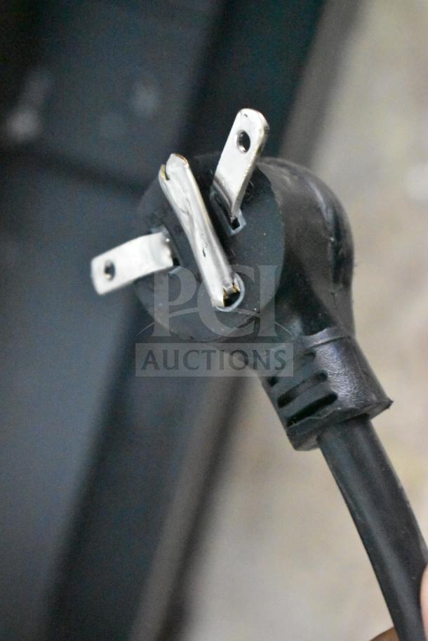 A close-up of a black, three-pronged power plug for the 2019 True GDM-72-HC Cooler Merchandiser, 115 volts, 1 phase.