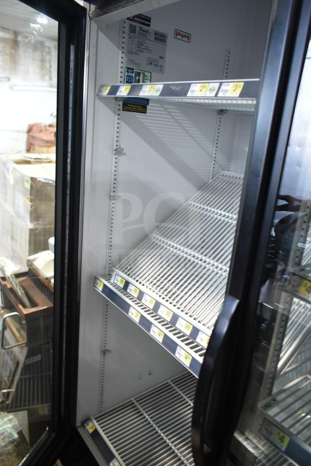 2019 True GDM-72-HC 3-door reach-in cooler merchandiser, 115V, 1 phase. Features shelves and product labels inside.
