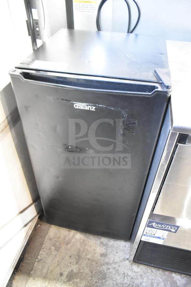 Galanz GLR33MBKE23 Mini Cooler, black, 115 Volts, 1 Phase, visible dent on door, logo at top.