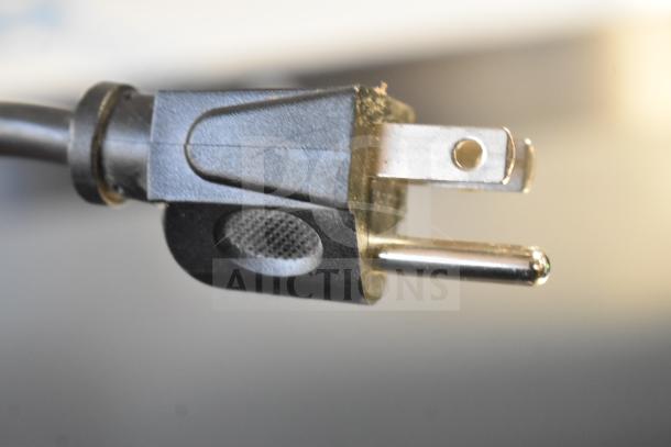 Power plug of Galanz GLR33MBKE23 Mini Cooler, 115 Volts, 1 Phase. Black with visible prongs, indicating power connection type.