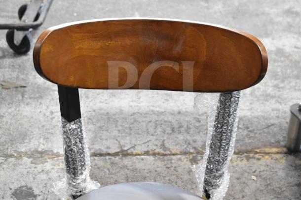 Brand new Lancaster Boomerang chair with wooden backrest, gray cushion, and metal frame. Model: 164CBMRGBFRN.