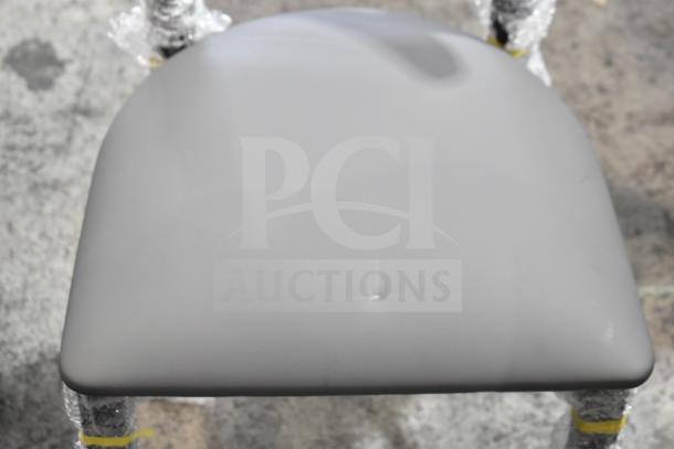 14 new Lancaster dining chairs with gray cushions, wooden backrests, and metal frames; minor scratch visible on seat.