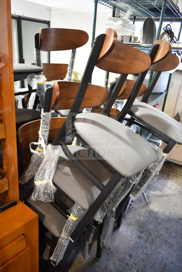 16 brand new Lancaster Boomerang dining chairs, wooden back, gray seat, metal frame, wrapped in protective material. Model 164CBMRGBFRN.