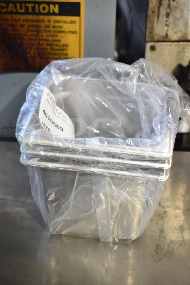 Stacked stainless steel steam table pans in plastic wrap, labeled with item number 4070669, indicating an anti-jam design.