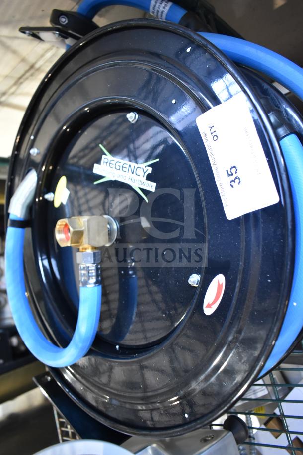 Regency black powder-coated steel hose reel with blue hose, brand new with minor scratches, visible logo and tags.