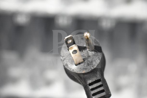 Crane 5800-4 vending machine plug close-up. Three-prong attachment, slightly worn. Image shows plug detail.