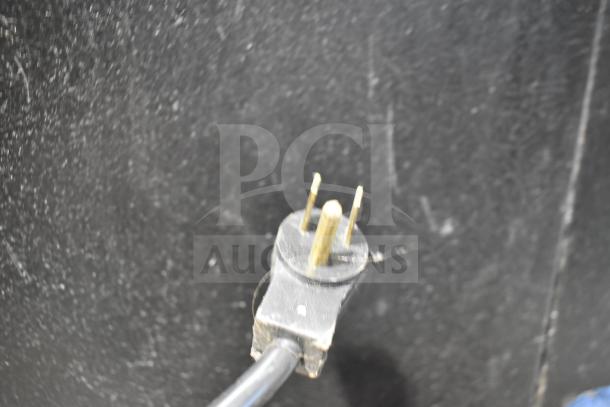 Close-up view of the power plug for a Beverage Air BB48Y-1-B commercial cooler. Black cord, three-prong plug.