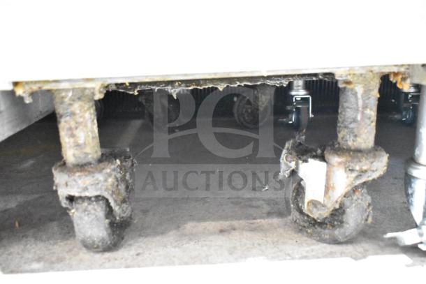 Pitco Frialator commercial gas deep fryer on casters, showing wear and rust on wheels.