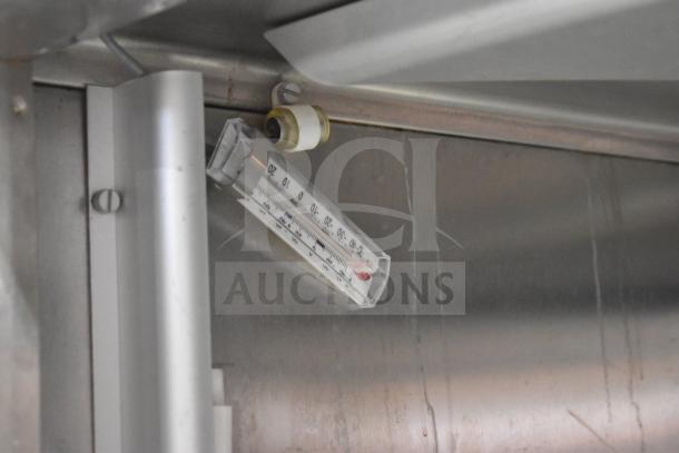 Thermometer inside Traulsen RHT 2-32NUT commercial cooler, displaying temperature range. Stainless steel interior.