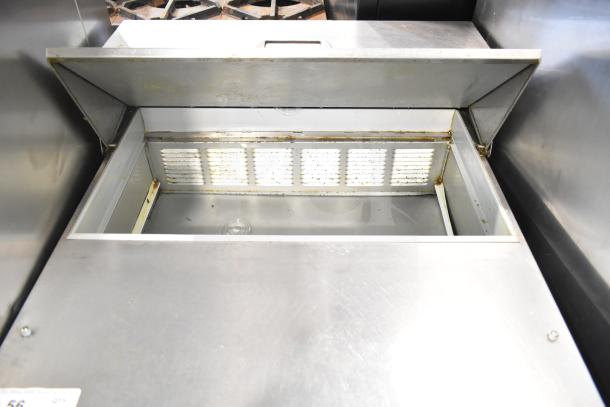 Beverage Air SPE27-B commercial prep table with open top. Visible stainless steel surface, moderate wear, vent detail inside.