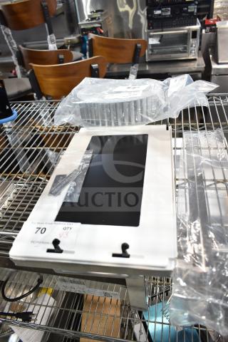 Three brand new scratch and dent items with blower wheel, on a metal shelf. Includes packaged components and labels.