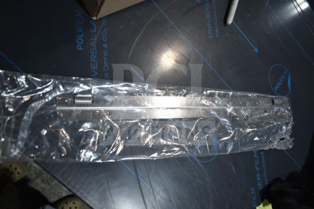 Brand new blower wheel in clear packaging, showing minor scratches, placed on a blue Polifilm surface.