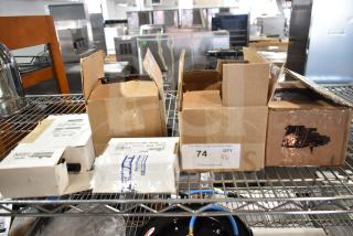 Boxes containing brand new scratch and dent items: oil pump, float switch, ignition module. Auction tag reads "74 QTY."
