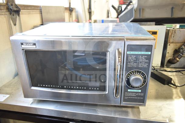 Sharp R-21LCFS countertop microwave oven, stainless steel, commercial model, 1000W, 120V, control dial visible.