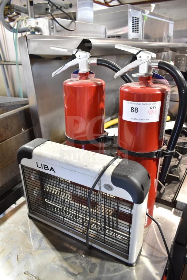 Three-item auction set with two red fire extinguishers and a Liba bug zapper, in used condition, with visible auction tags.