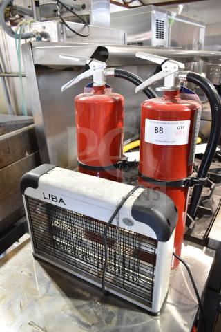 Three-item auction set with two red fire extinguishers and a Liba bug zapper, in used condition, with visible auction tags.