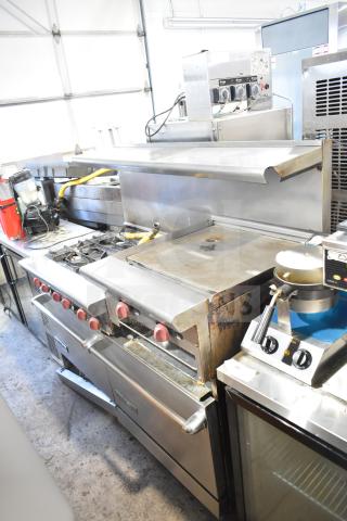 American Range commercial 6 burner range with flat top, 2 ovens, over shelf, and backsplash. Good condition.