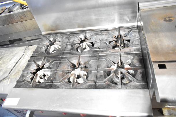 American Range commercial 6 burner range with flat top, two ovens, over shelf, and backsplash. Used condition.