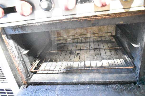 American Range commercial 6 burner oven interior, showing wear on wire rack and metal surfaces.