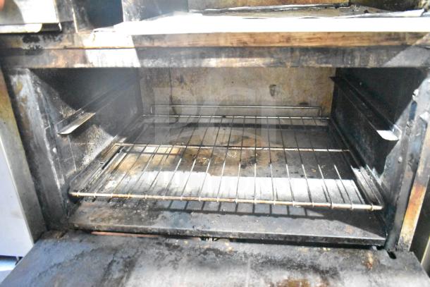 American Range commercial oven interior, showing wire rack. Moderate wear with visible grease and rust.