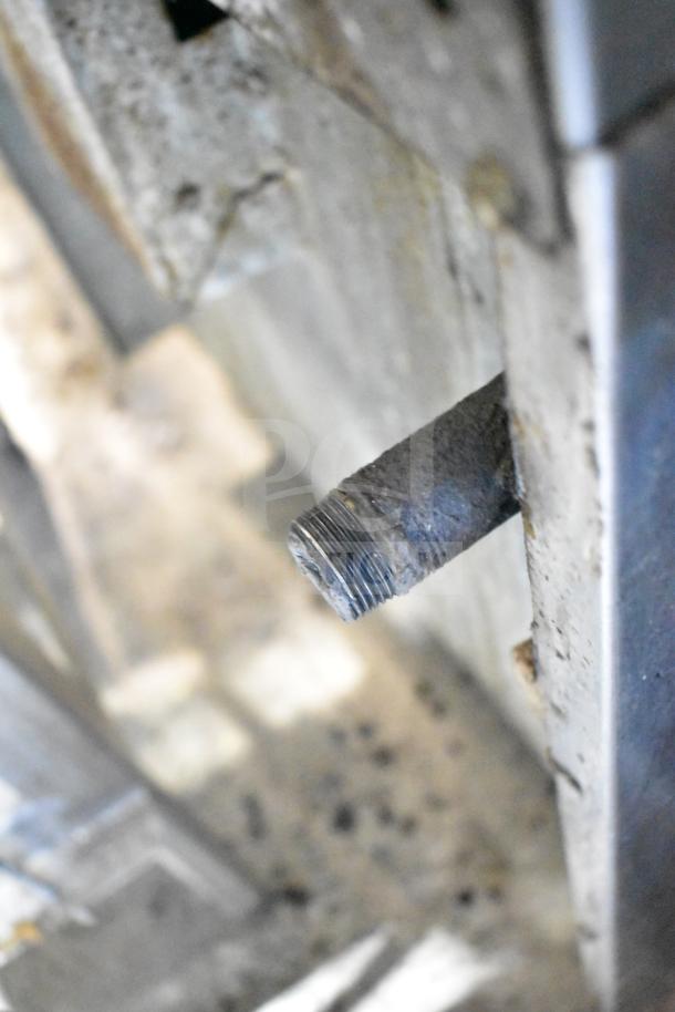 Alt text: "Close-up of American Range commercial stove, showing a sturdy metal pipe connector, indicating durability."