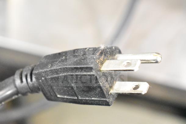 Close-up of a plug for a Curtis ALP3GT12A000 Coffee Machine, showcasing its 3-prong design, indicating 120V compatibility.