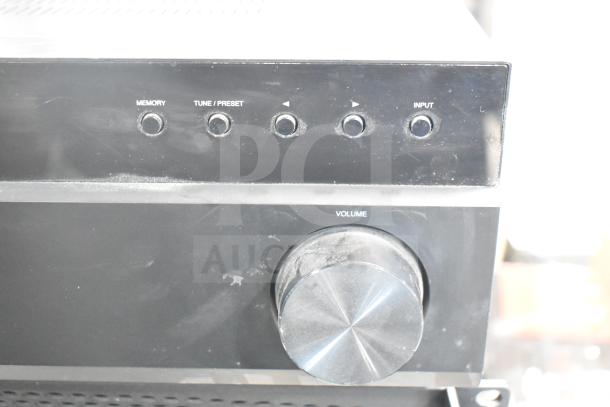Insignia Stereo Receiver NS-STR514, close-up of front panel with volume knob and input buttons, in used condition.