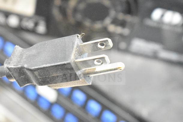 Power cord plug with electronic equipment in background, featuring Furman M-8Lx, dbx Zone Pro 640m, Insignia NS-STR514, Crown CDi2000.