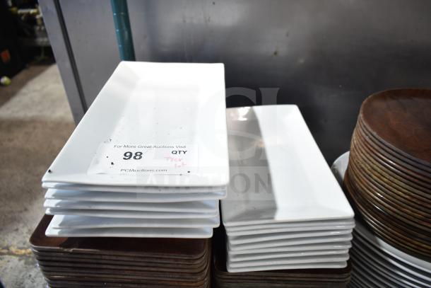 Stack of white rectangular plates in good condition, auction lot number 98, with visible label from PCIAuctions.com.