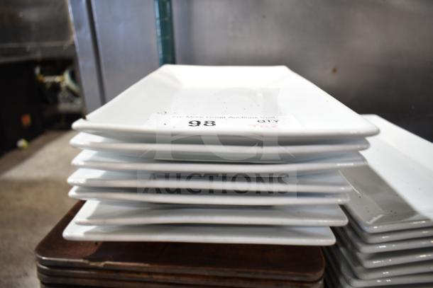 Stack of white rectangular plates with auction tag marked "98 QTY." Plates appear to be in good condition.