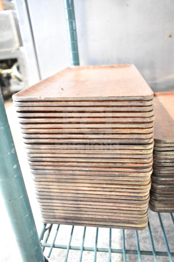 Stack of wooden rectangular plates on metal rack, signs of wear, part of tier lot including baskets.