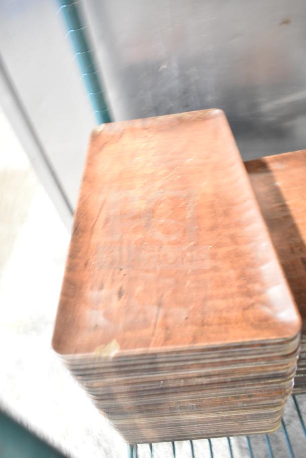 Stack of rectangular wooden plates in used condition with visible wear, part of a tier lot including various items.