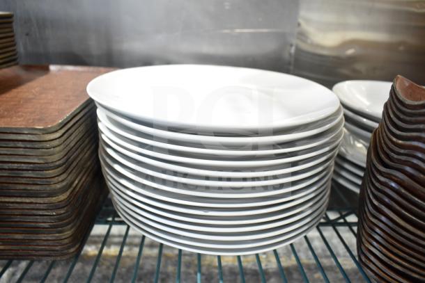 Stacked white rectangular plates, metal baskets on wire shelf. Used condition, part of a mixed auction lot.